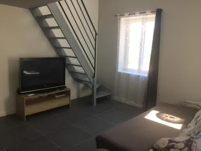 a living room with a tv and a staircase at Au bon logis Luberon 50m2 in Cheval-Blanc