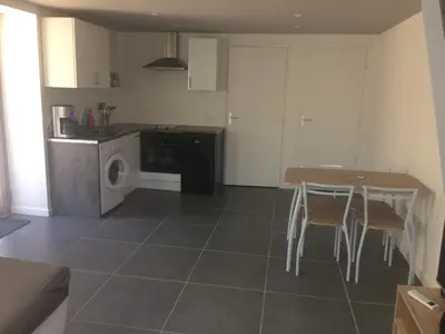 a kitchen with a table and a washing machine at Au bon logis Luberon 50m2 in Cheval-Blanc