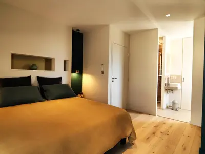 a bedroom with a large bed and a bathroom at Les Loges En Provence 