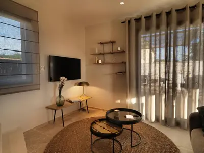 a living room with a large window and a tv at Les Loges En Provence 