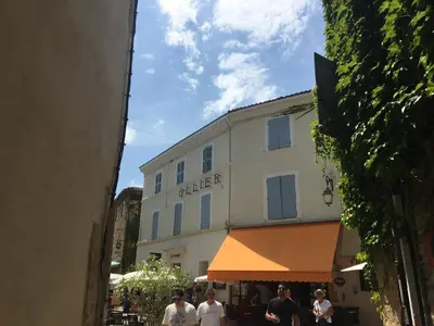 a group of people walking down a street in front of a building at Le cœur de Lourmarin Loulou en Luberon in Lourmarin