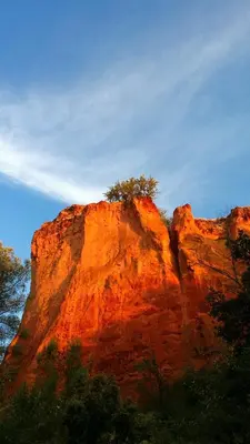 a rocky mountain with trees in front of it at La Dame Au Balcon in Roussillon