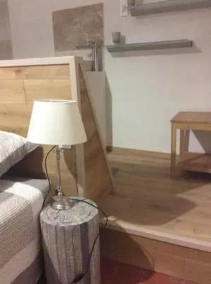 a lamp sitting on a table next to a bed at Maison Daumas Billard Français et Piscine in Robion en Luberon