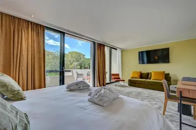 a hotel room with a large bed and a living room at Best Western Sévan Parc Hôtel in Pertuis