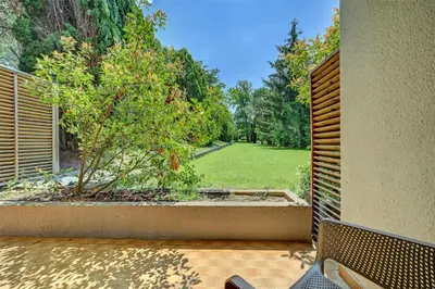 a view of a garden from a patio with a bench at Best Western Sévan Parc Hôtel in Pertuis