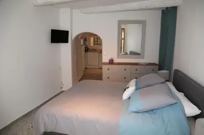 a bedroom with a bed and a dresser and a mirror at La Bignone in LʼIsle-sur-la-Sorgue