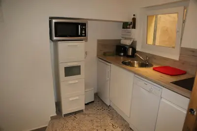 a small kitchen with a sink and a microwave at La Bignone in LʼIsle-sur-la-Sorgue