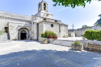 an old stone church with a bench in front of it at Appartement de caractère entre St Rémy et Avignon, 74m2, 2 à 4 personnes in Noves