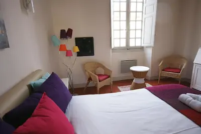 a bedroom with a bed and chairs and a window at Appartement de caractère entre St Rémy et Avignon, 74m2, 2 à 4 personnes in Noves