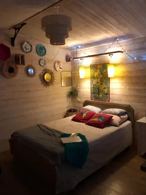 a bedroom with a bed in a room with wooden walls at Les cabanes de Vallis Clausa in Saumane-de-Vaucluse