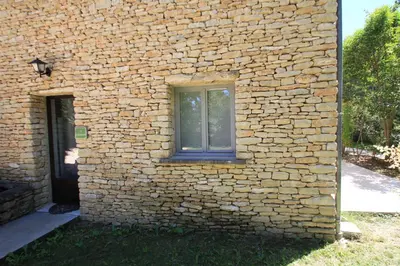 a window on the side of a brick building at La Caprine in Gordes