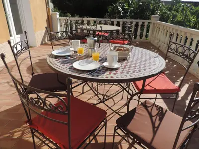 a table with plates and cups and chairs on a patio at 1001 Ocres in Apt