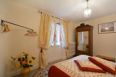a bedroom with a bed and a vase of flowers at Gîte familial de charme, piscine chauffée en Provence in Le Thor