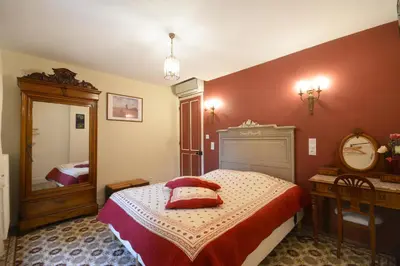 a bedroom with a bed and a mirror at Gîte familial de charme, piscine chauffée en Provence in Le Thor