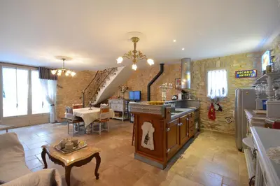 a living room with a kitchen and a dining room at Gîte familial de charme, piscine chauffée en Provence in Le Thor