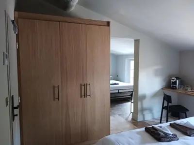 a bedroom with a large wooden cabinet next to a bed at Hotel La Bastide d'Eygalières in Eygalières
