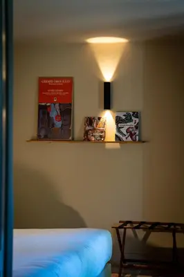 a room with a bed and a light on the wall at Hotel La Bastide d'Eygalières in Eygalières