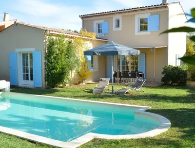 a villa with a swimming pool in front of a house at Lagrange Vacances - Le Clos Savornin in Saint-Saturnin-les-Apt