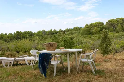 a white table and chairs in a field at Mas de la Gonnette in Venasque