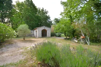 a small building with a bike parked in a yard at Ancien Mas Du Moulin in Eygalières