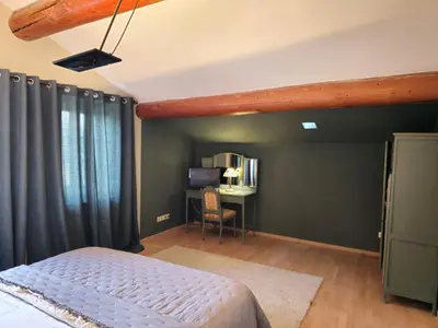 a bedroom with a bed and a desk with a chair at Ancien Mas Du Moulin in Eygalières