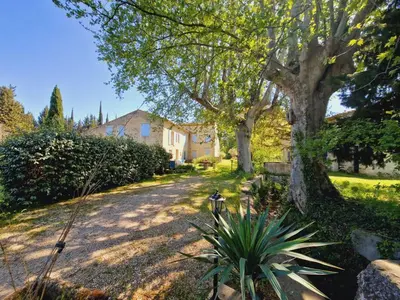 a yard with a house and a tree at Ancien Mas Du Moulin in Eygalières