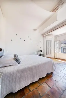 a white bedroom with a bed and a large window at La Prévôté - Luxury Chambres d'hôtes & Gastronomic Restaurant in LʼIsle-sur-la-Sorgue