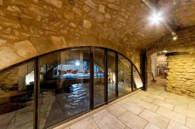 a room with a large glass window in a stone wall at La Prévôté - Luxury Chambres d'hôtes & Gastronomic Restaurant in LʼIsle-sur-la-Sorgue