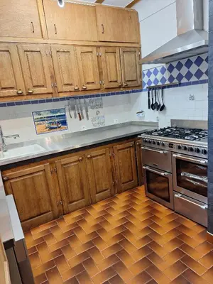 a kitchen with wooden cabinets and a wooden floor at Les Vallons Holiday Home in Lioux