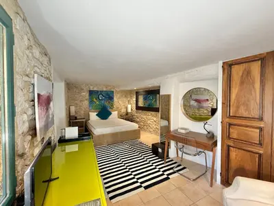 a living room with a bed and a desk in a room at La Belugue in Beaumont-de-Pertuis