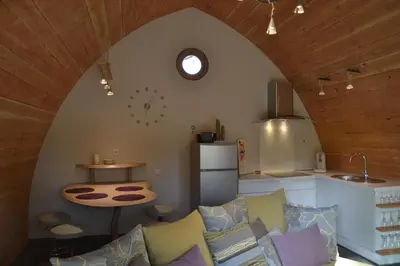 a living room with a couch and a kitchen at Cabanons Jour & Nuit in Mazan