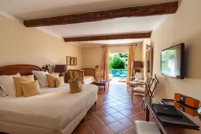 a bedroom with a bed and a living room at Le Phébus & Spa – Relais & Châteaux in Joucas
