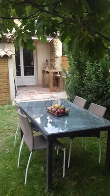 a dining room with a table and some windows at L'Orgalière Alpilles in Orgon