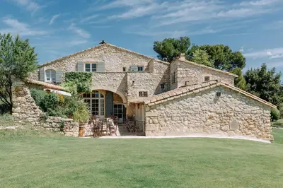 a large stone house with a stone wall at Le Mas De La Rose - Teritoria in Orgon