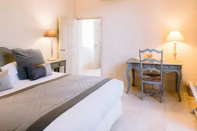 a bedroom with a bed and a desk with a chair at Le Mas De La Rose - Teritoria in Orgon