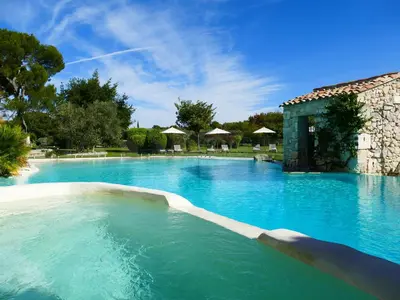 a large swimming pool with blue water at Le Mas De La Rose - Teritoria in Orgon