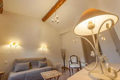 a living room with a couch and a table with a lamp at Hotel Sainte Anne - Apt in Apt