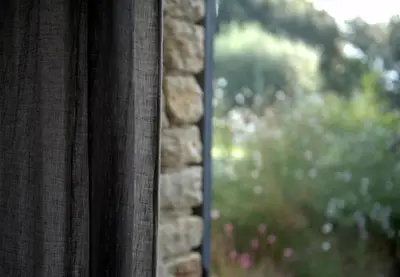 a window with a view of a stone wall at Les Terrasses - Gordes in Gordes