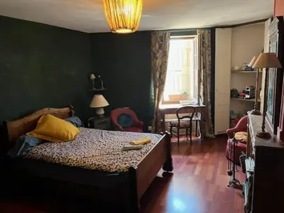 a bedroom with a bed and a chair in a room at Suite Provençale in Saignon