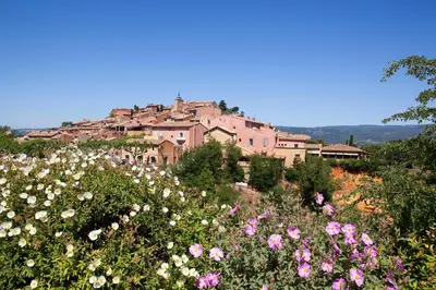 a town on top of a hill with flowers at Hotel Les Ambres in Roussillon