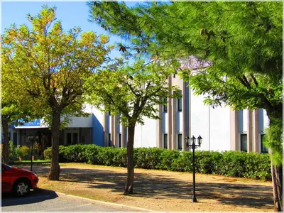 a white building with trees in front of it at Aix Hotel in Aix-en-Provence