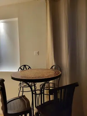 a table and chairs in a room with a curtain at Gite A.M Hoche in Lançon-Provence
