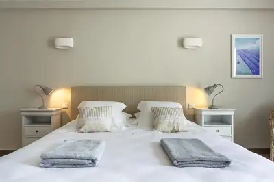 a bedroom with a white bed with two pillows on it at Les Terrasses du Luberon in Bonnieux