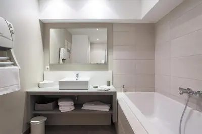 a bathroom with a sink and a tub and a mirror at Les Terrasses du Luberon in Bonnieux