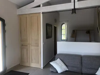 a living room with a couch and a wooden door at le Mas des Pignes -adults only in Aix-en-Provence