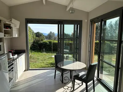 a kitchen with a table and chairs and a window at le Mas des Pignes -adults only in Aix-en-Provence