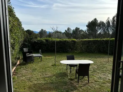 a table and chairs sitting in a yard at le Mas des Pignes -adults only in Aix-en-Provence