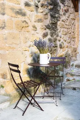 a table with a chair and a coffee cup on it at Su Lei Campanes in Lauris