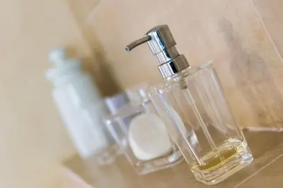 a glass container with a faucet next to a toilet at Su Lei Campanes in Lauris