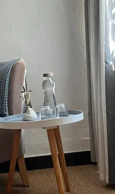 a table with a glass bottle on top of a chair at Su Lei Campanes in Lauris